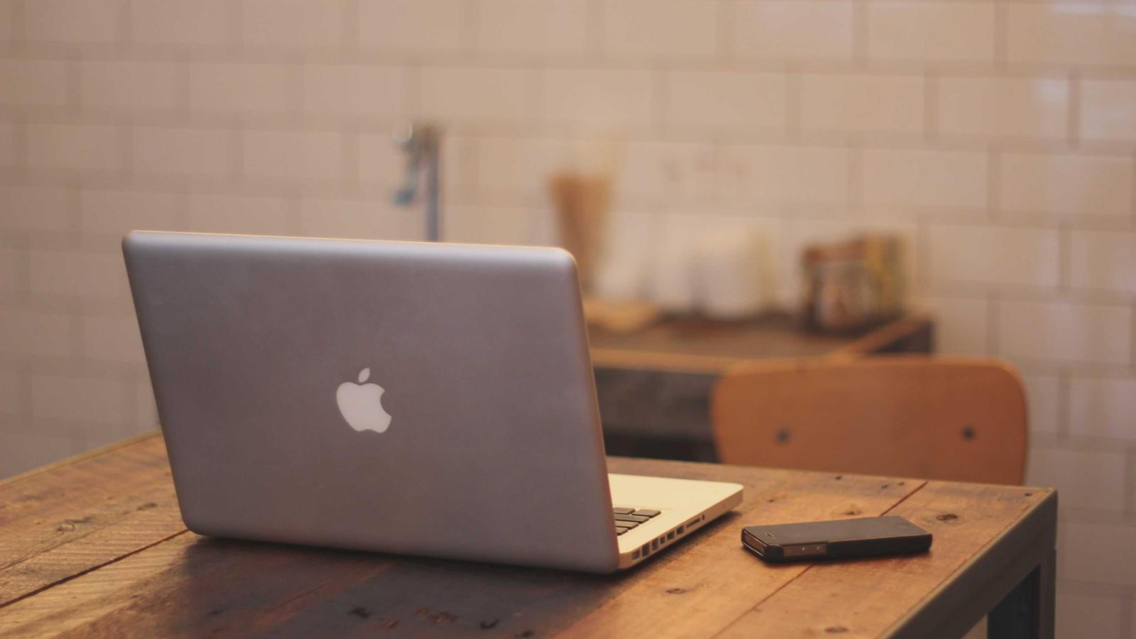 Laptop and notebook open on a desk during a planning session